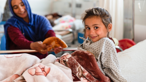 Spenden für Kinder: Mutter reicht Tochter in Krankenbett Brot