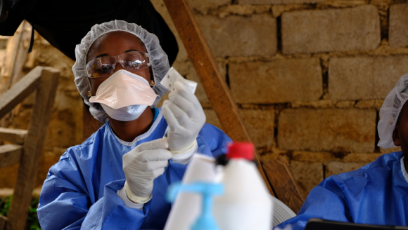 Eine Person in Schutzkleidung bereitet eine Ebola-Impfung vor.