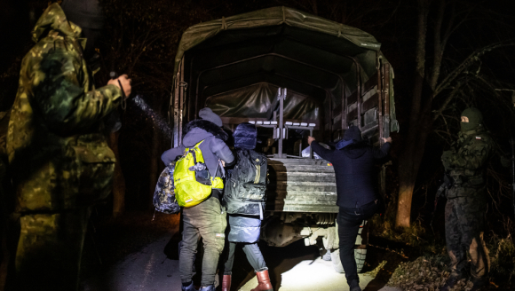 Militärfahrzeug und Geflüchtete an der Grenze zu Polen