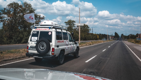 Ein weißer Krankenwagen mit dem Logo von Ärzte ohne Grenzen fährt auf einer Straße.