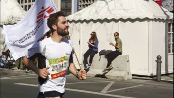 Ein Läufer unseres Spendenlauf-Teams beim Berliner Halbmarathon trägt eine Ärzte ohne Grenzen-Fahne - er läuft für den guten Zweck Läufer mit Ärzte ohne Grenzen-Fahne