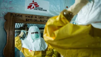 Monrovia: Eine Mitarbeiterin zieht sich ihre Schutzkleidung an, bevor sie auf die Ebola-Station geht. Mitarbeiterin im Ebola-Einsatz in Schutzkleidung
