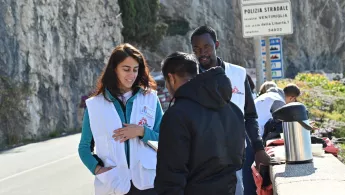 Zwei Mitarbeiter*innen von Ärzte ohne Grenzen sprechen mit einem Geflüchteten in Ventimiglia, Italien Zwei Mitarbeiter*innen sprechen mit Geflüchtetem