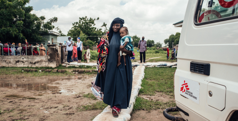 Wir behandeln Mangelernährung in Nigeria. Frau trägt Töchter auf Arm