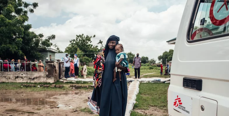 Wir behandeln Mangelernährung in Nigeria. Frau trägt Töchter auf Arm