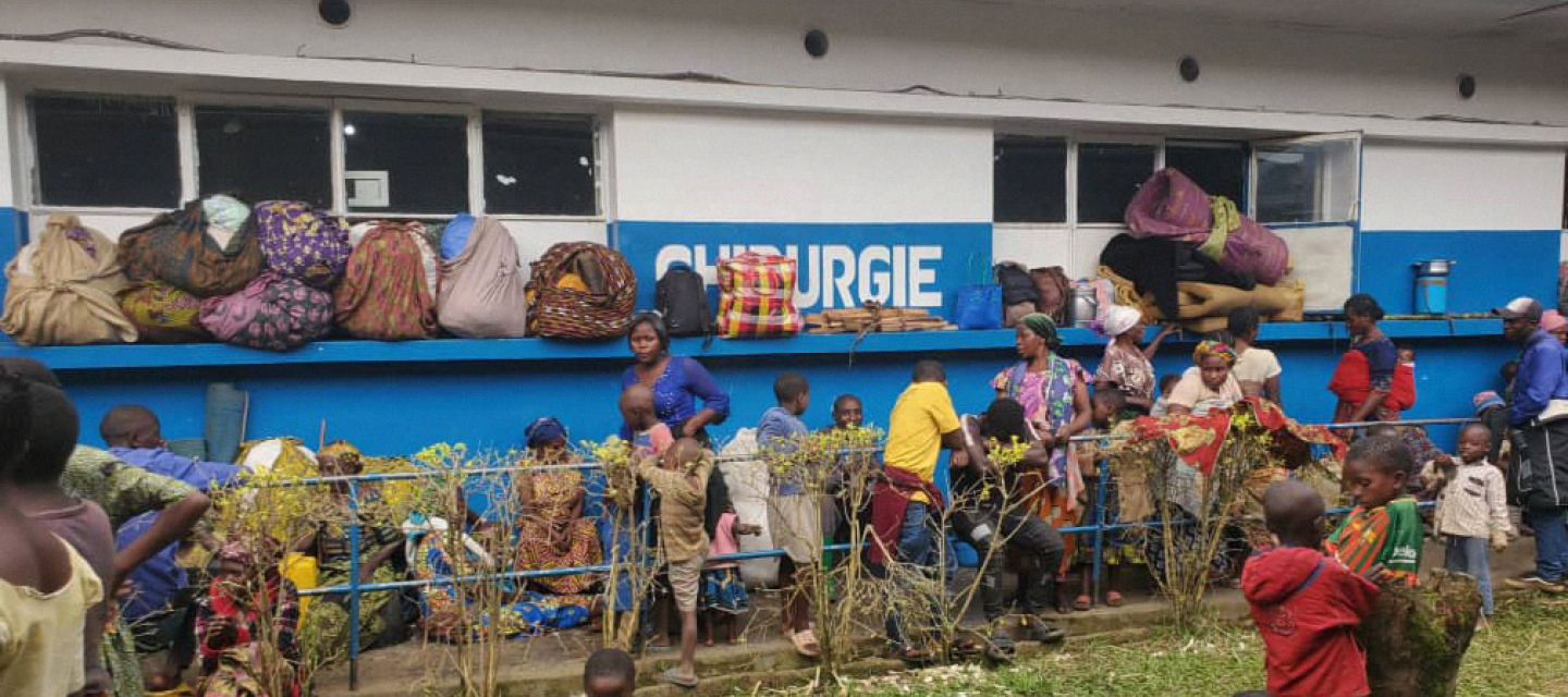 Schutzsuchende sitzen vor einem Krankenhaus, in Nord-Kivu  in der DR Kongo.