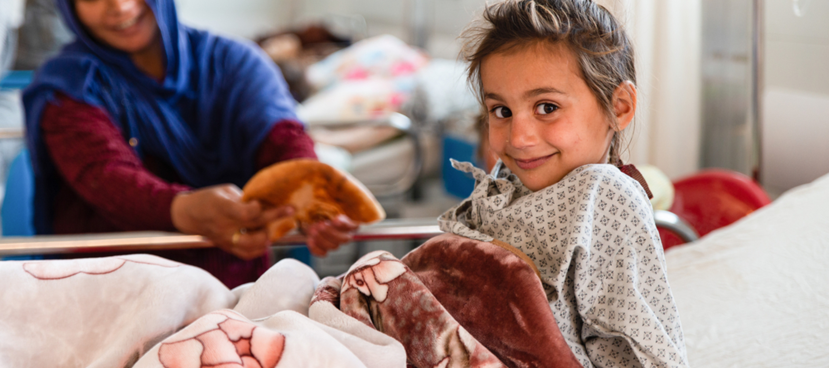 Spenden für Kinder: Mutter reicht Tochter in Krankenbett Brot