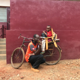 Der 8-jährige Dieu-Beni und sein Vater auf einem Fahrrad.