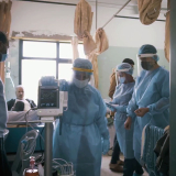 Medizinisches Personal mit Covid-19-Ausrüstung in einem Krankenhauszimmer 