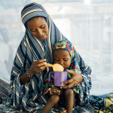 Eine Mutter füttert ihre 2-jährige Tochter auf der Mangelernährungsstation in einem Krankenhaus in Niger