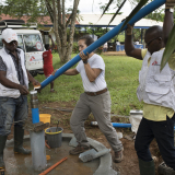 Drei Techniker*innen installieren eine Wasserpumpe in Nigeria.