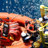 Eine gerettete Person klettert an Bord der Geo Barents