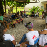 Kolumbien: Mitarbeitende spricht in Kreis von afro-kolumbianischen und indigenen Gemeinschaften