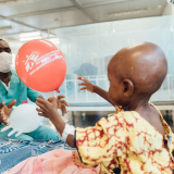 Pfleger bringt kleinen Patientin einen Luftballon