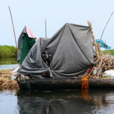 Ein selbst gebautes Floß mit einem Zelt darauf treibt auf dem Wasser