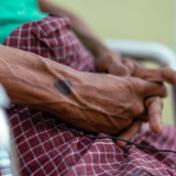 Ein tätowiertes Herz auf der Hand eines Patienten, der in unserer mobilen Klinik behandelt wird. 