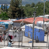 Ein Aufnahmezentrum für Geflüchtete in Samos, umgeben von einem hohen Stacheldrahtzaun