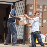 Logistiker*innen verräumen Kisten mit medizinischen Hilfsgütern