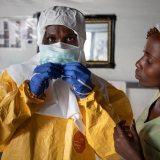 Mitarbeiter in Schutzausrüstung vor Ebola-Transitzentrum