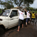 Geflüchtete Uganda Teamarbeit Geländewagen